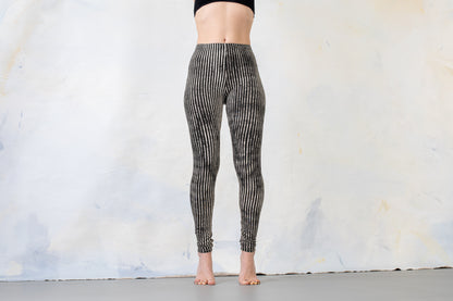 Model trägt schwarz-beige gestreifte Leggings, Aufnahme von vorne.