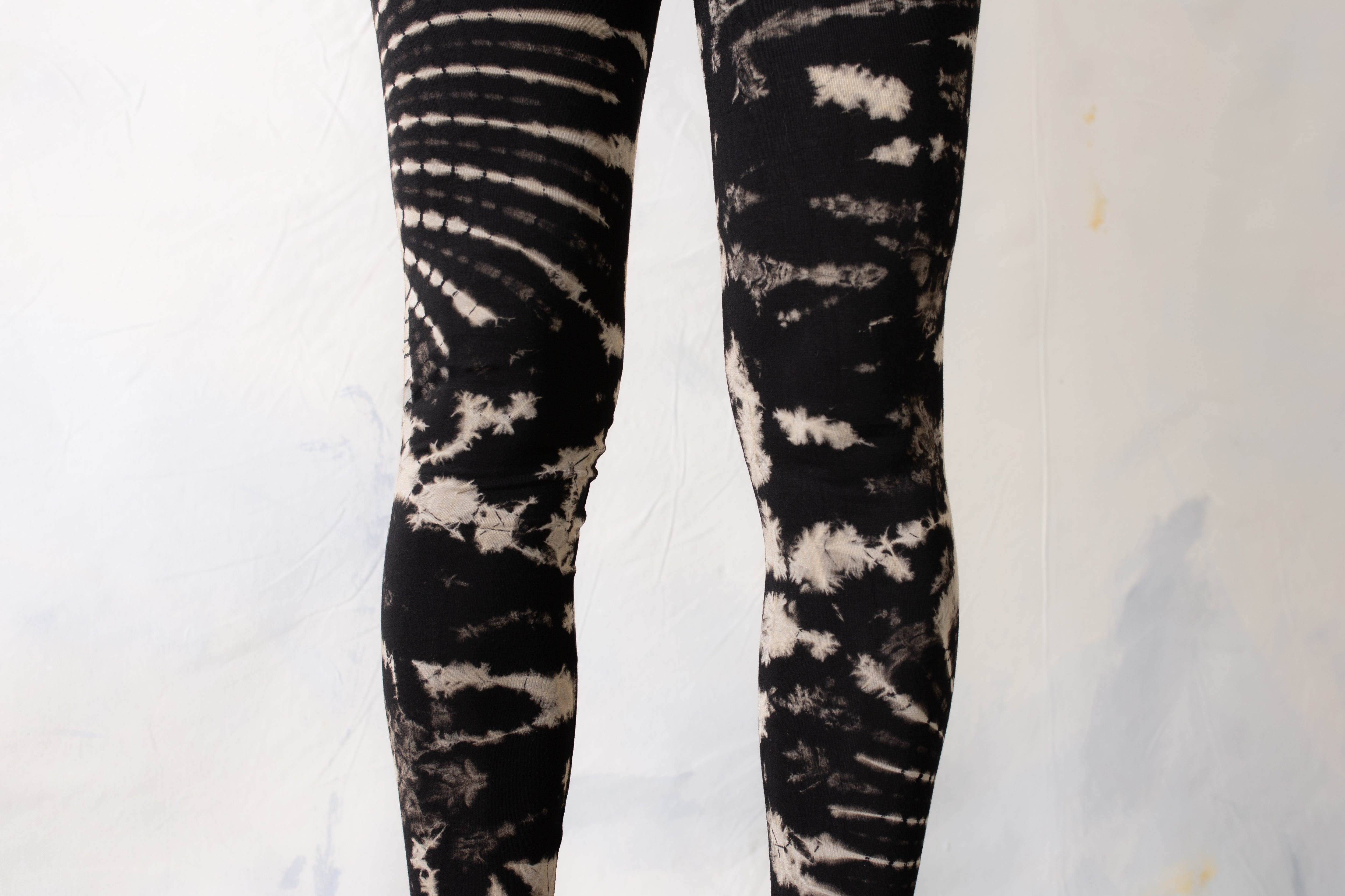 Nahaufnahme abstraktes Blumenmuster auf elastischer Yoga Leggings im Batik Tie-Dye Style in schwarz-beige-grau 