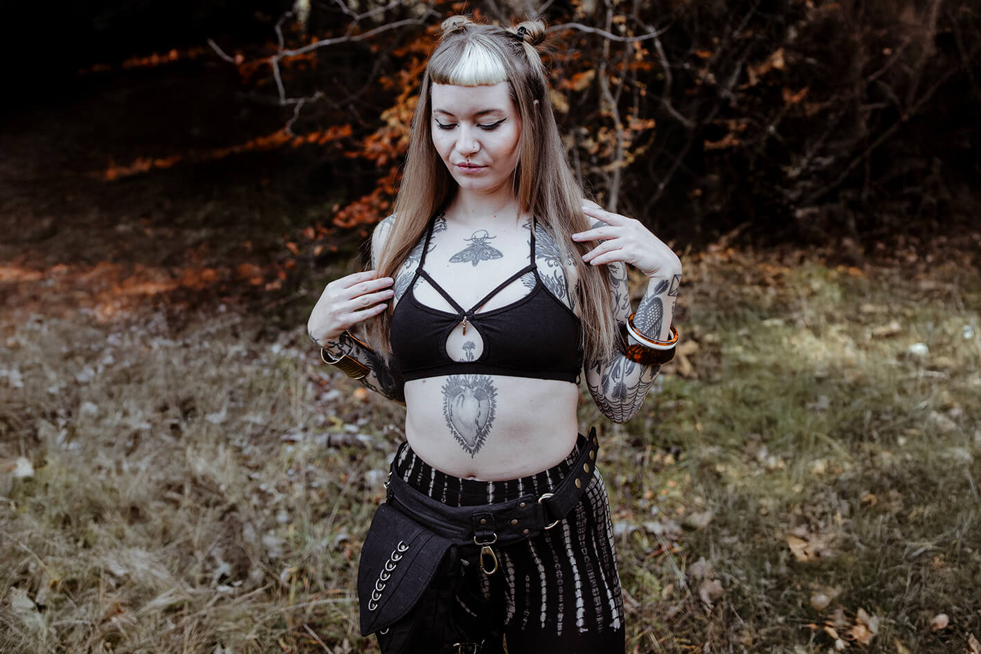 Ausdrucksstarkes Model im Wald  trägt einen Strappy Bra und eine Batik Leggings mit abstraktem Reptilien-Print
