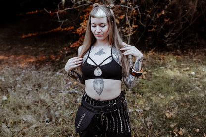 Ausdrucksstarkes Model im Wald  trägt einen Strappy Bra und eine Batik Leggings mit abstraktem Reptilien-Print