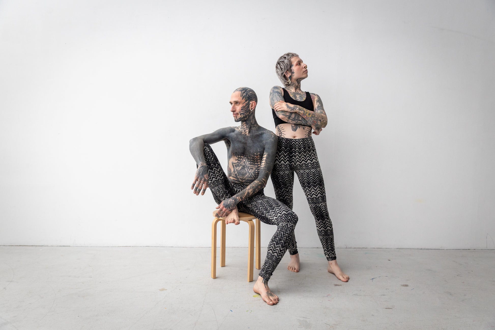 Batik-Leggings mit abstraktem geometrischem Muster in schwarz-beige-grau, getragen an zwei Models, Aufnahme von vorne.
