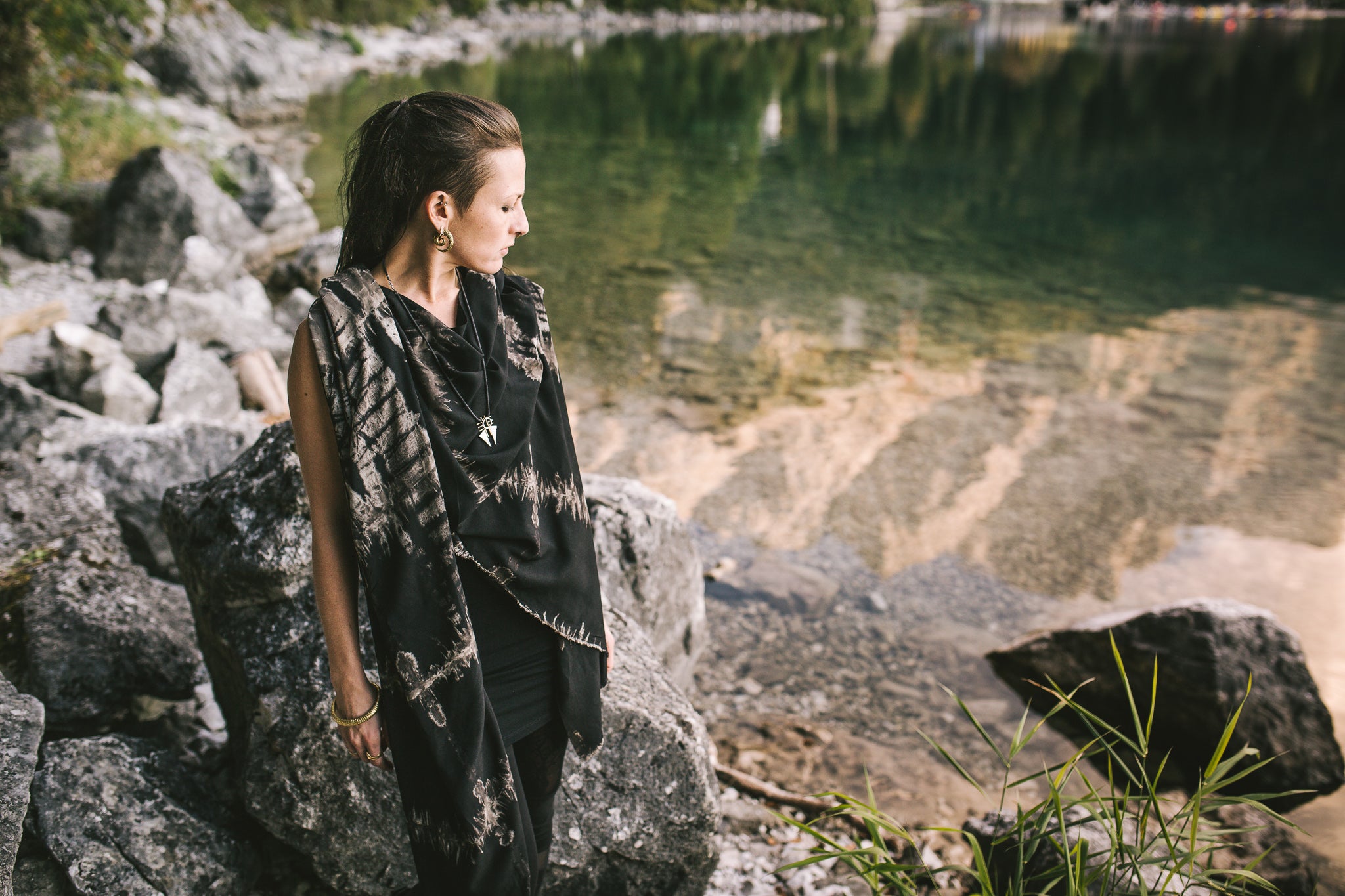 Model in der Natur mit schwarzem Viskose-Sarong mit abstraktem Batikmuster in Beige und Grau