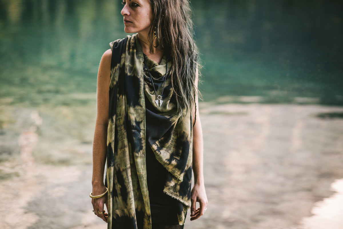 Model trägt einen dunkelblauen Sarong aus Viskose als Schal mit geometrischen türkis-beigem Batik-Muster in der Natur