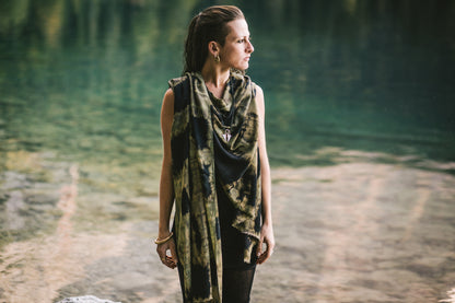 Frau in der Natur mit einem dunkelblauen Viskose-Sarong als Schal, verziert mit türkis-beigem geometrischen Batik-Muster
