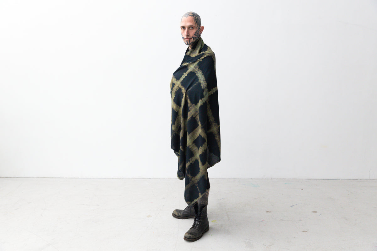 Männlich gelesenes Model trägt großen Viskose-Sarong um den Körper geschlungen.