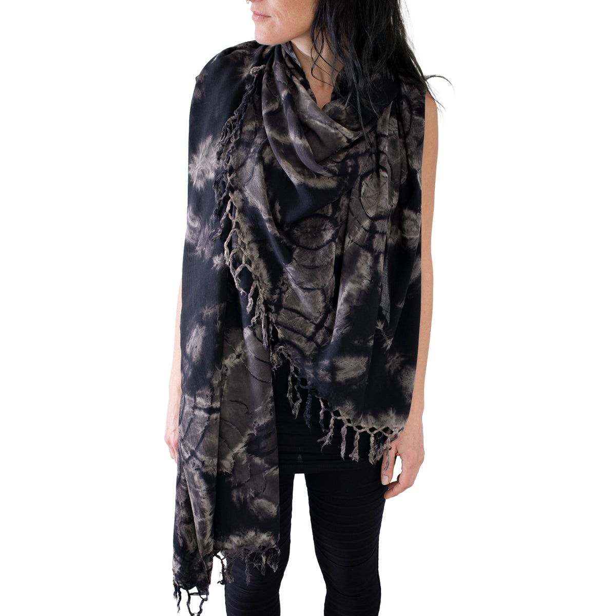 Model trägt einen schwarzen großen Viskose-Sarong mit floralem Batikmuster und Fransen in beige-grau