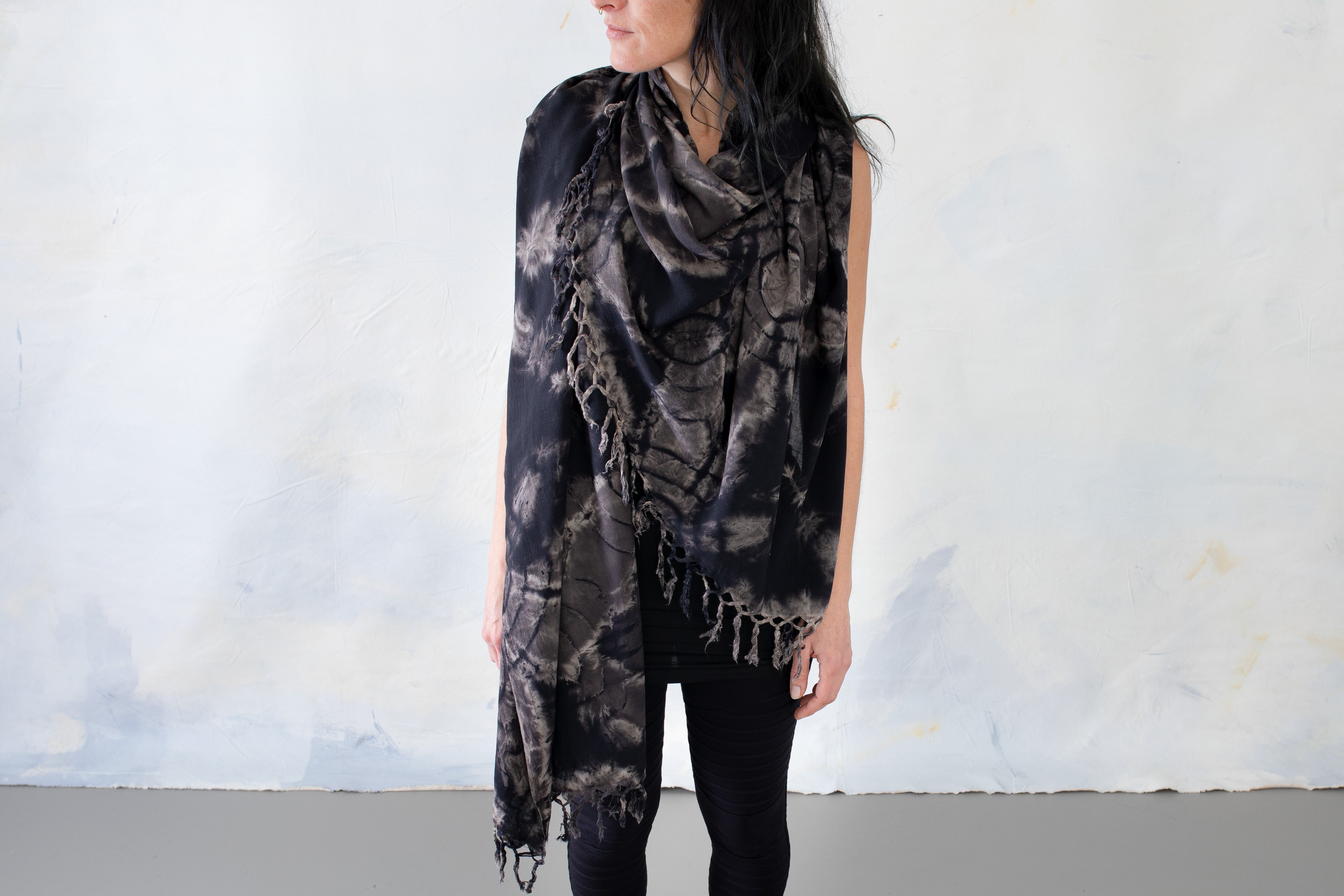 Schwarzer Sarong mit beige-graue  Batikmuster um Hals und Oberkörper getragen