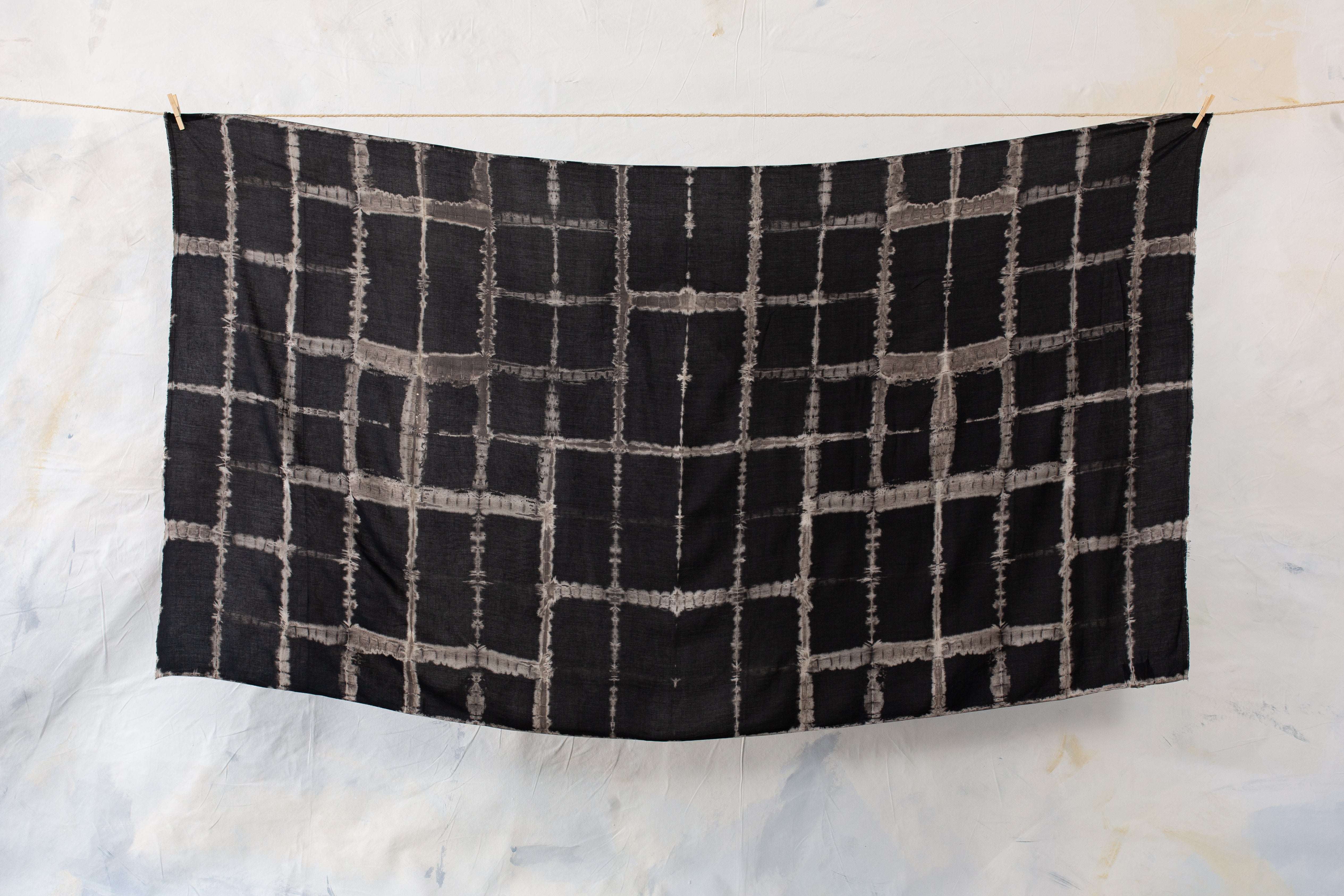 Schwarzer Viskose-Sarong mit grau-beigem geometrischen Batik-Muster und fließender Stoffstruktur aufgespannt