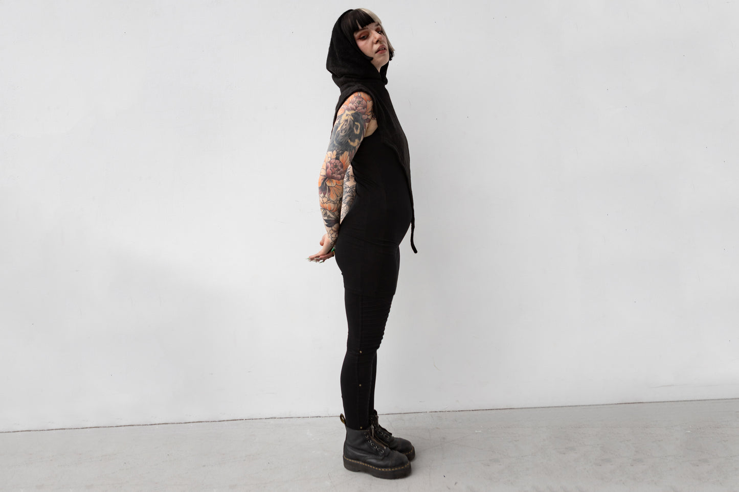 Weiblich gelesenes Model trägt Schalkapuze mit asymmetrischem Schnitt und großem Zipfel