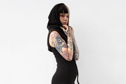 Model trägt schwarze Schalkapuze aus Strick mit Zipfel vorne