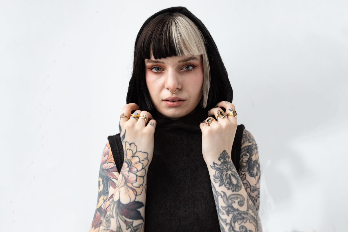 Detailaufnahme der Schalkapuze, weiches Strickmaterial in Schwarz mit asymmetrischem Schnitt