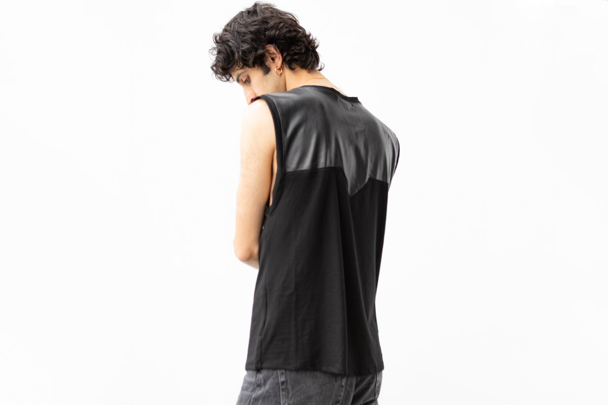 Männliches Model von hinten trägt schwarzes Tanktop mit Kunstlederdetail am Rücken, tiefen Armausschnitten und markanten Nähten auf der Brust