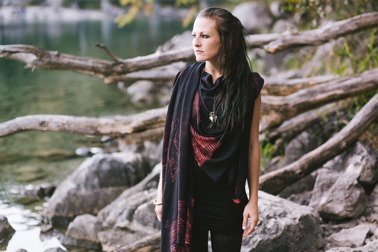 Frau trägt schwarz roten Sarong  vor traumhafter Naturkulisse